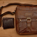 Set of leather bag and wallet on a wooden background